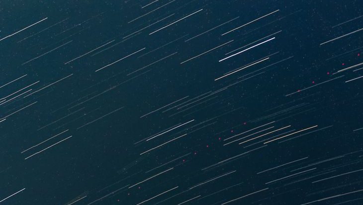 Star trails across midnight sky. Image via Pexels.